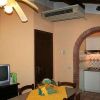 Sala da pranzo con tavolo, TV, ventilatore a soffitto e cucina con arco.