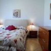 Camera da letto con letto matrimoniale, abat-jour e pareti bianche.