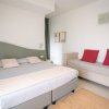 Camera con letto matrimoniale e divano con cuscini rossi.