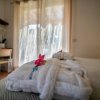 Accappatoio bianco con fiore sul letto.
