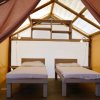 Interno di una tenda con due letti singoli e luci soffuse.