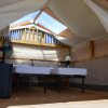 Interno di una tenda glamping con due letti singoli, ventilatore e lucernario.