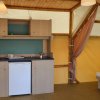 Interno di una tenda con cucina in legno, mini frigorifero e letto.