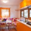 Cucina moderna con arredamento arancione e finestra.