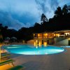Piscina illuminata di sera con lettini.