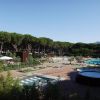 Complesso di piscine circondate da alberi e spazi verdi.