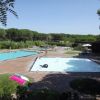 Due piscine all'aperto circondate da alberi e area verde.