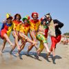 Persone in costumi colorati sulla spiaggia.
